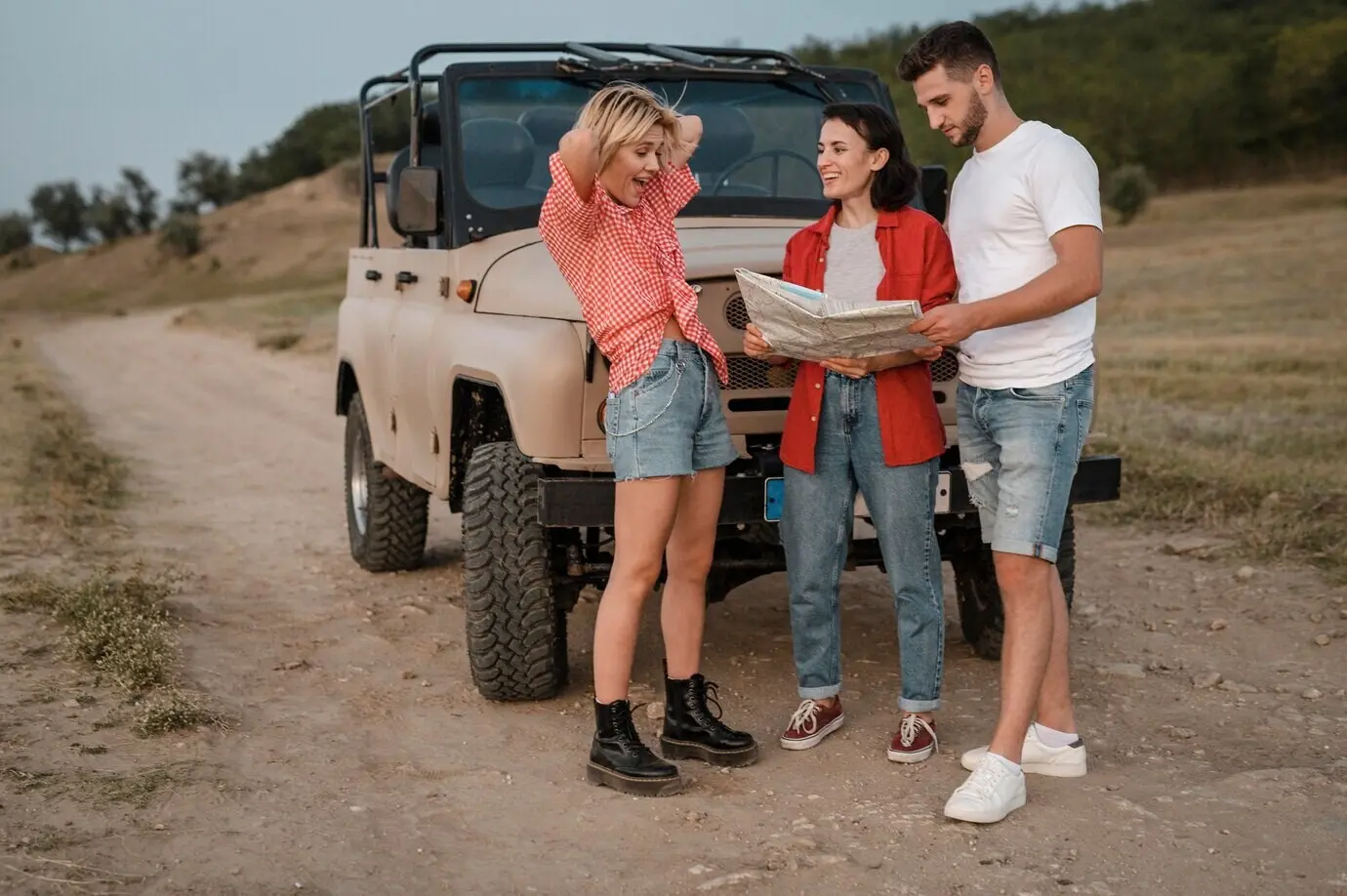 Drei gute Freunde schauen während der Autofahrt auf eine Karte.